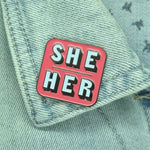 She Her pink pronoun pin on collar of denim jacket