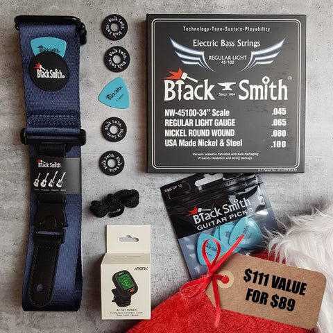 BlackSmith navy blue guitar strap, blue guitar picks, 45/100 nickel wound bass strings, Aroma digital chromatic tuner, BlackSmith strap locks and a Christmas stocking on a grey background. Tag says '$111 value for $89" 