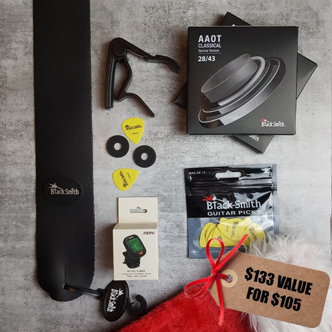 BlackSmith black leather strap, black strap locks, black capo, 2 pack normal tension nylon classical guitar strings, BlackSmith yellow pick, Aroma digital chromatic tuner and Christmas stocking. Tag reads "$133 value for $105"