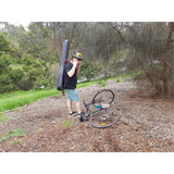 Man wearing CRDG205BGY Crossrock bass guitar gig bag with bicycle on ground