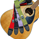 Four P&P Music guitar straps in different colours - red, black, purple and green - on an acoustic guitar