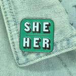 She Her Green pronoun pin on collar of denim jacket