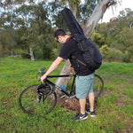 Man wearing CRS206EBK Crossrock electric guitar gig bag about to get on bike