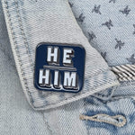 Blue He Him pronoun pin on collar of denim jacket