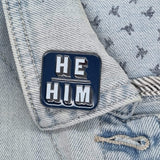 Blue He Him pronoun pin on collar of denim jacket