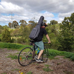 Man riding bike while wearing CRDG205EGY Crossrock deluxe metro series electric guitar gig bag