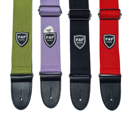 Four guitar straps in different colours - green, purple, black and red. The purple strap has a pick inside the pick holder