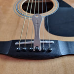 Metal pin puller is being used to pull a bridge pin from an acoustic guitar