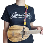 Double hook ukulele strap with brown PU leather shoulder pad attached to pineapple ukulele on model wearing Greenchords tshirt