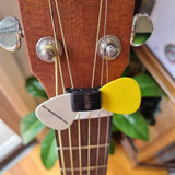 Rubber guitar pick holder on headstock of acoustic guitar with picks attached